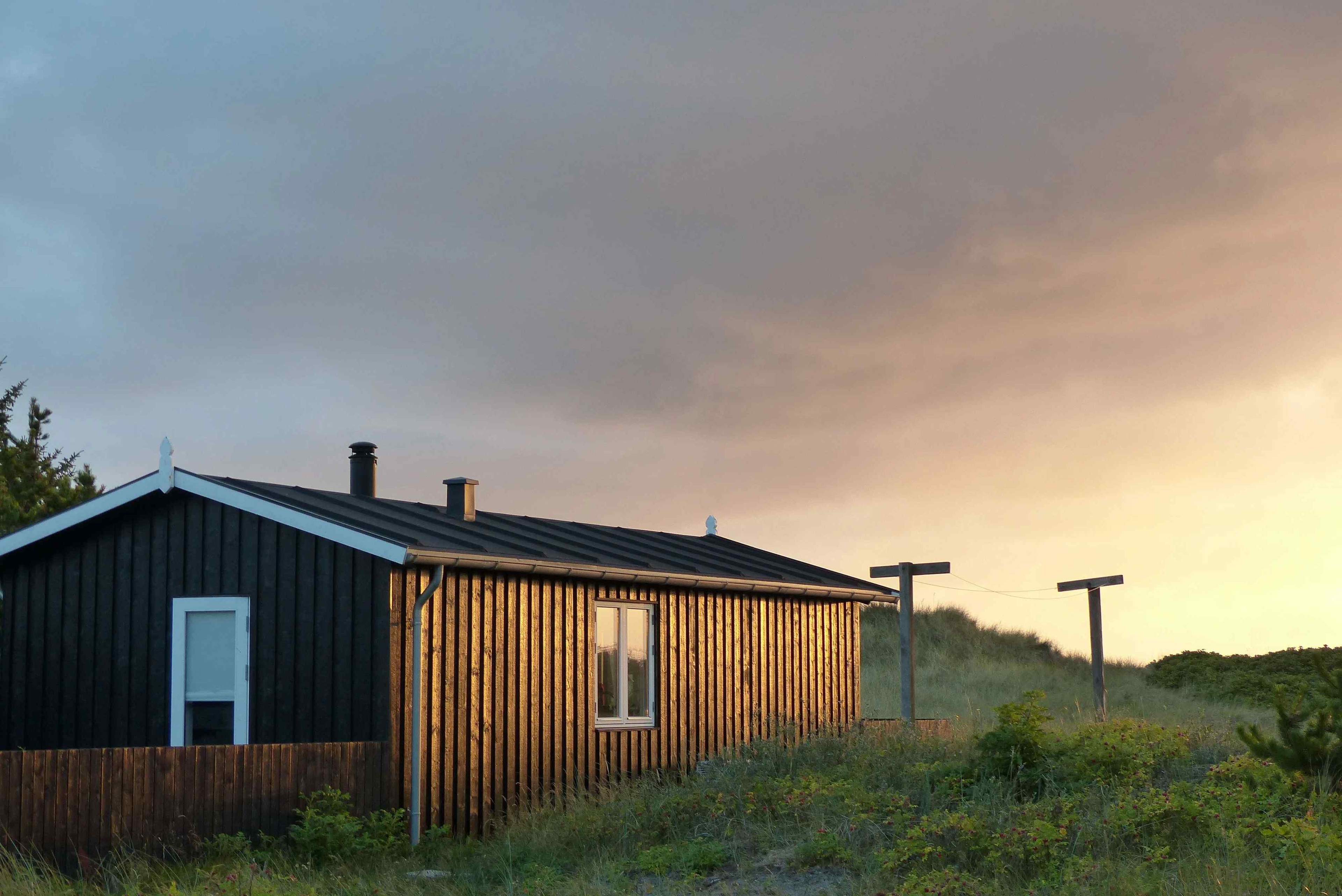 En hvid terrassedør i et sort træhus